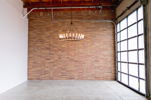 Versatile event space with rustic brick wall, ideal for weddings and corporate meetings.