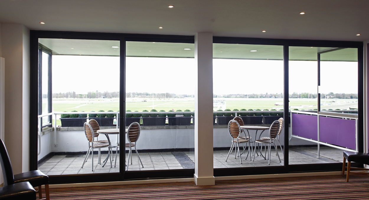 Modern meeting space at Kempton Park Racecourse with large glass windows for events.