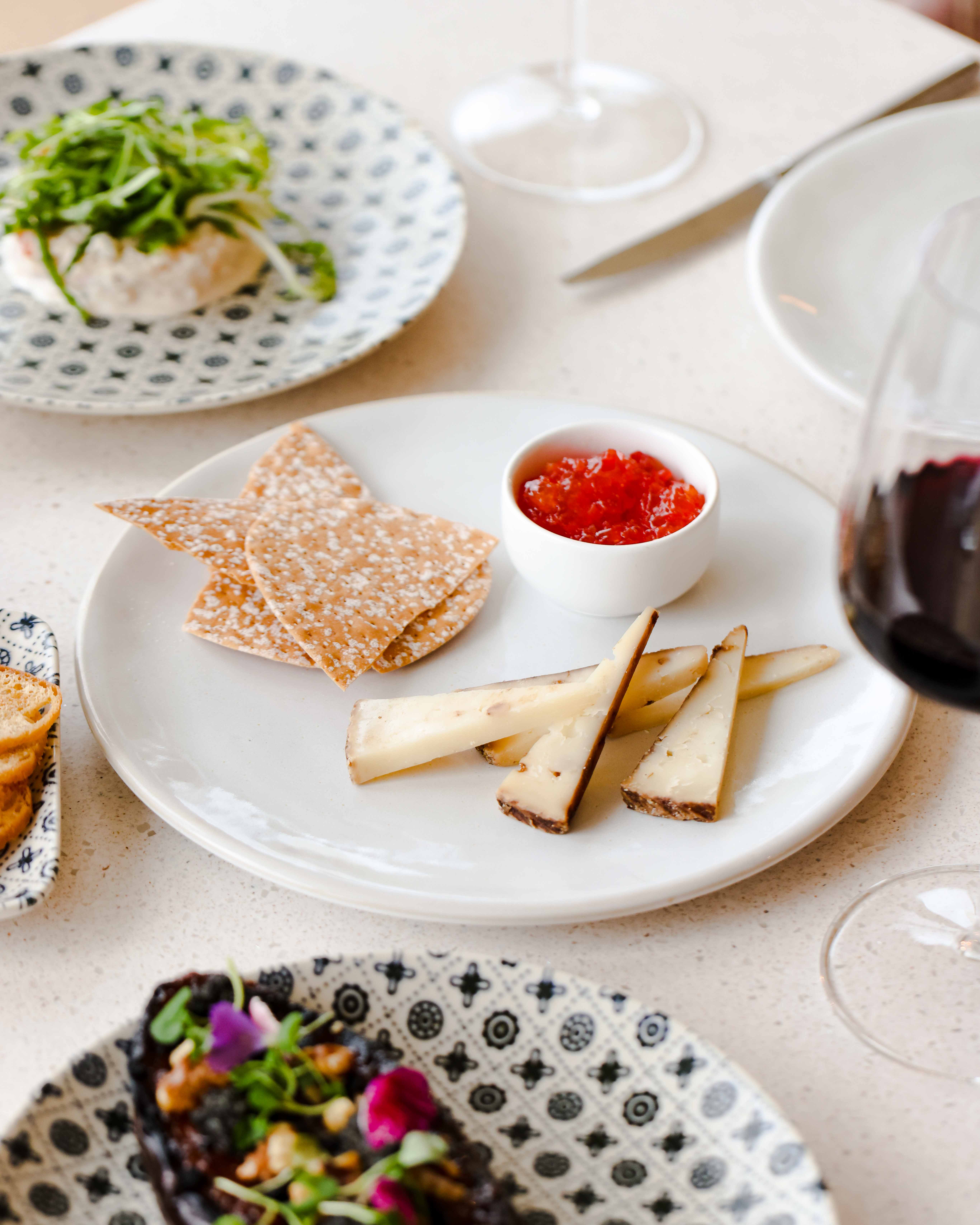 Appetizer plate with cheese and fruit preserve at JOIA Restaurant, perfect for events.