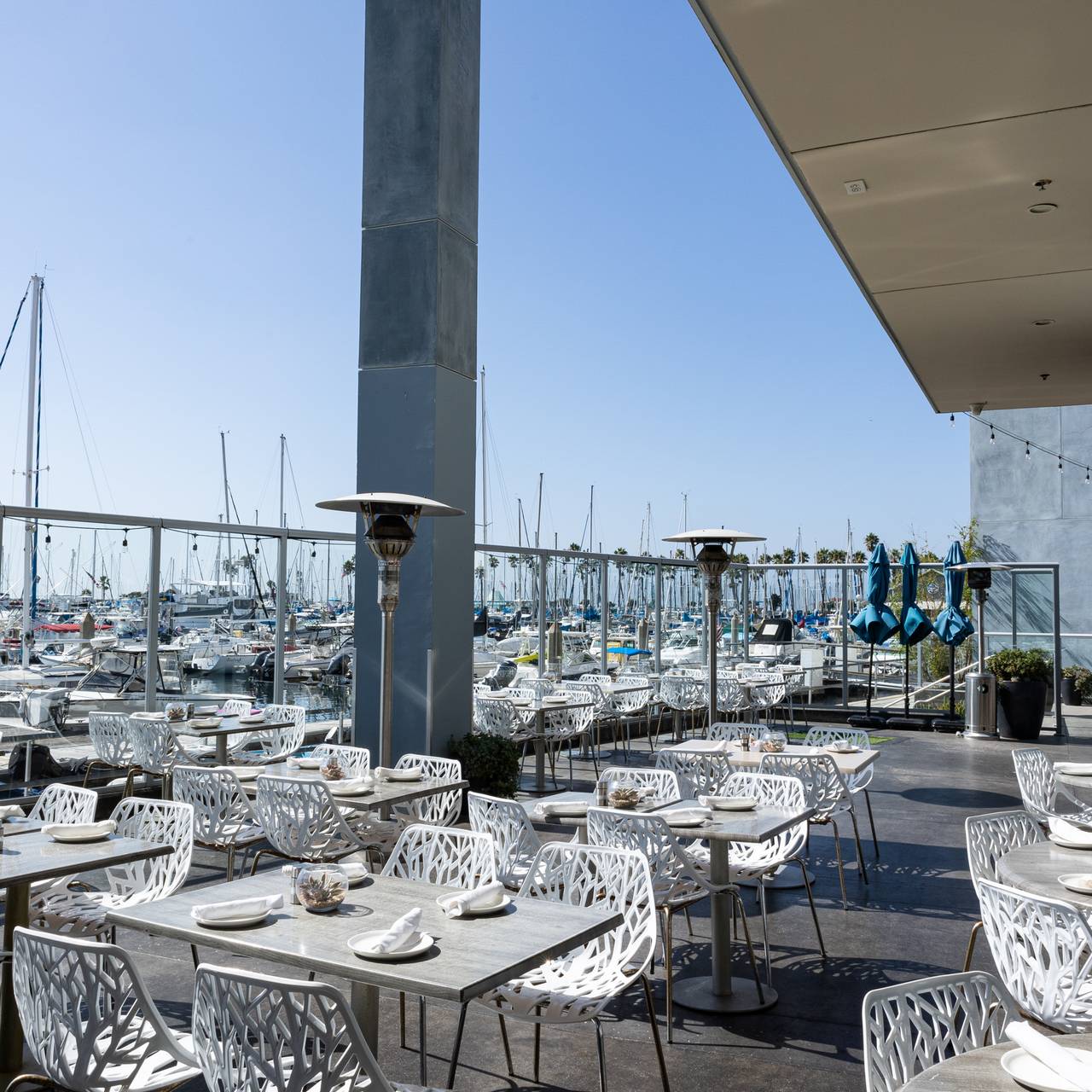 Outdoor dining area at Sea Level @ Shade, modern furniture, marina view for events.