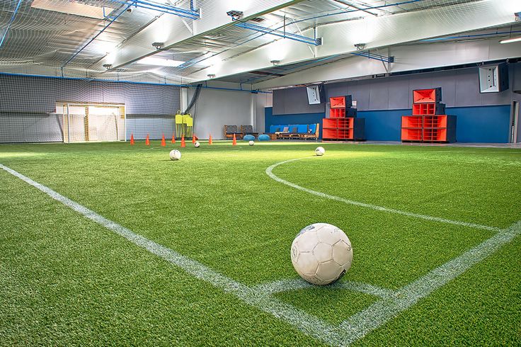 Indoor sports facility with artificial turf for team-building events and tournaments.