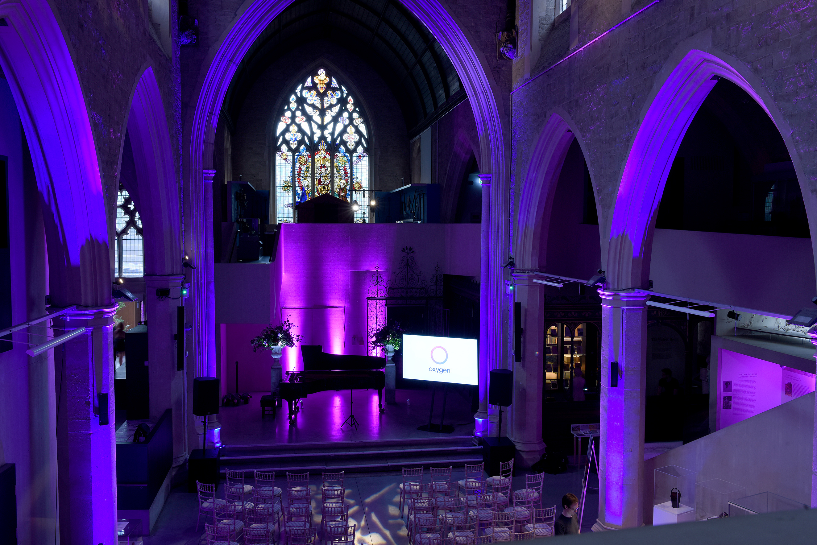 Elegant event space in historic church with purple lighting, ideal for corporate events.