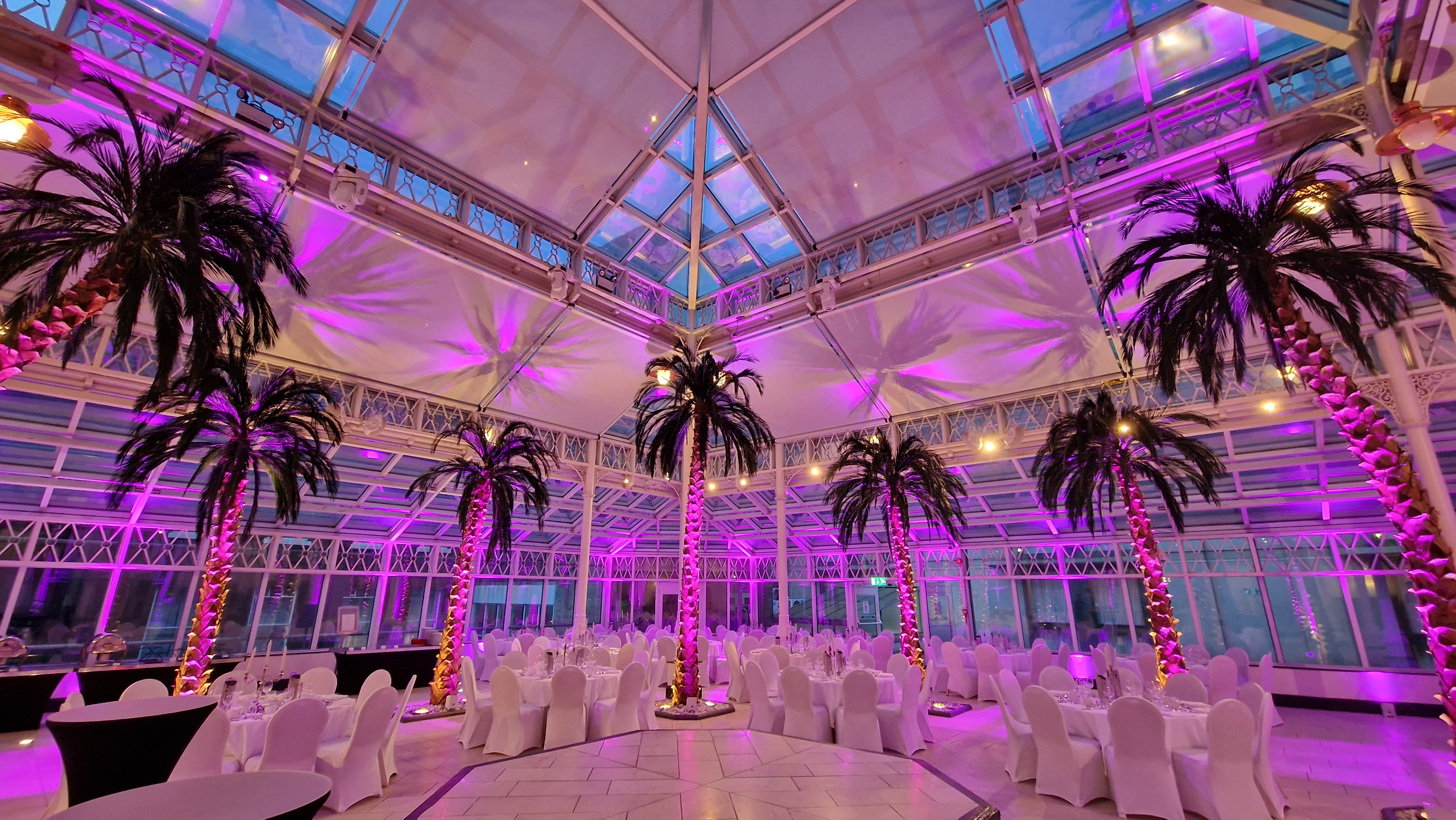 Elegant event space with white chairs and glass ceiling at Millennium Gloucester, London.