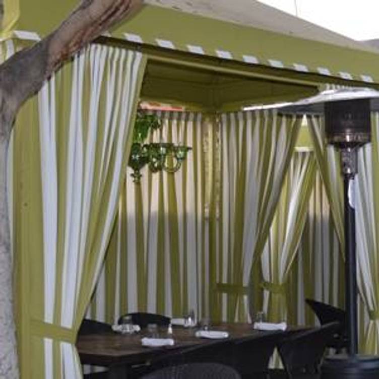 Wrap-around patio with striped curtains for elegant outdoor events at Ca' Del Sole.