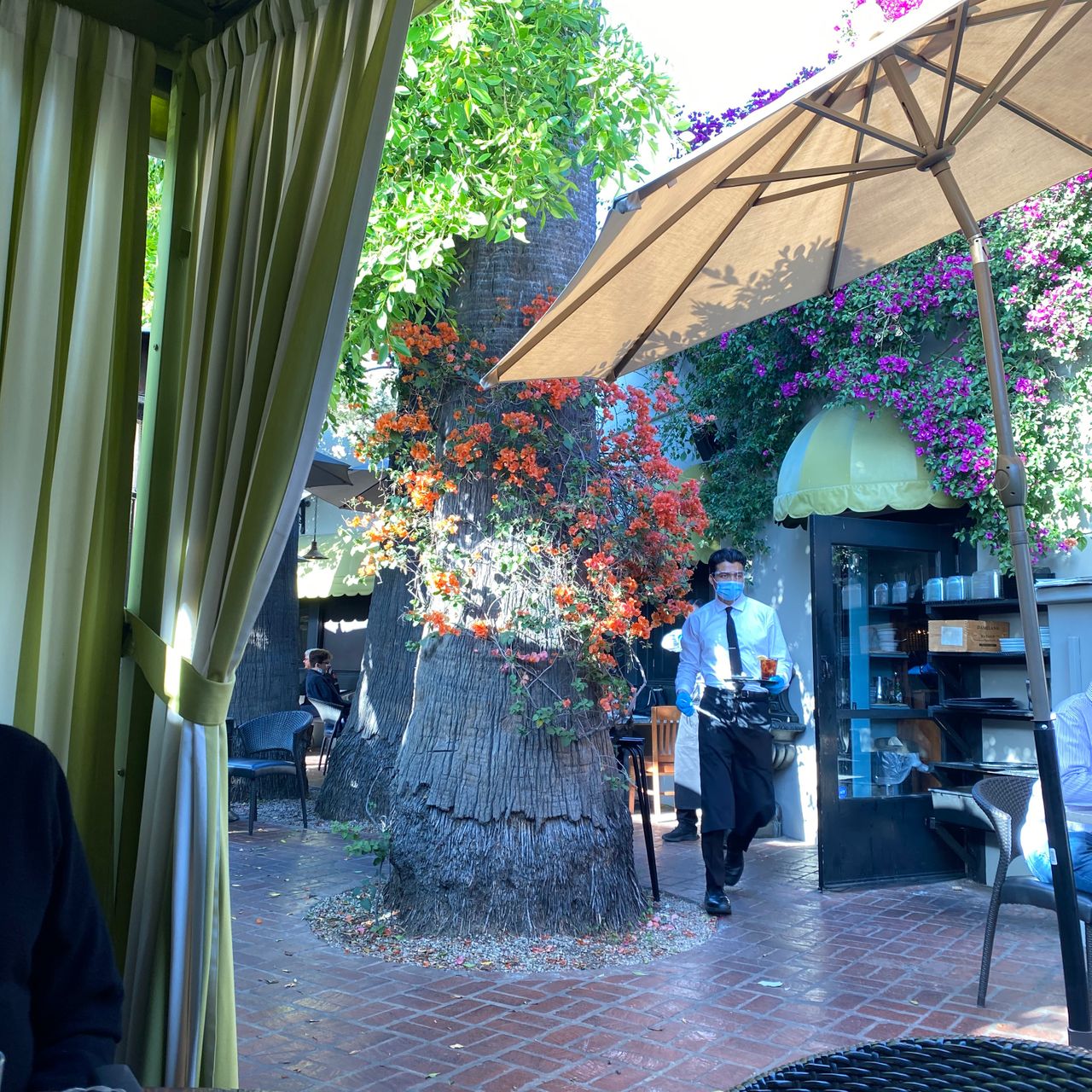 Wrap-around patio at Ca' Del Sole, perfect for events with lush greenery and attentive service.