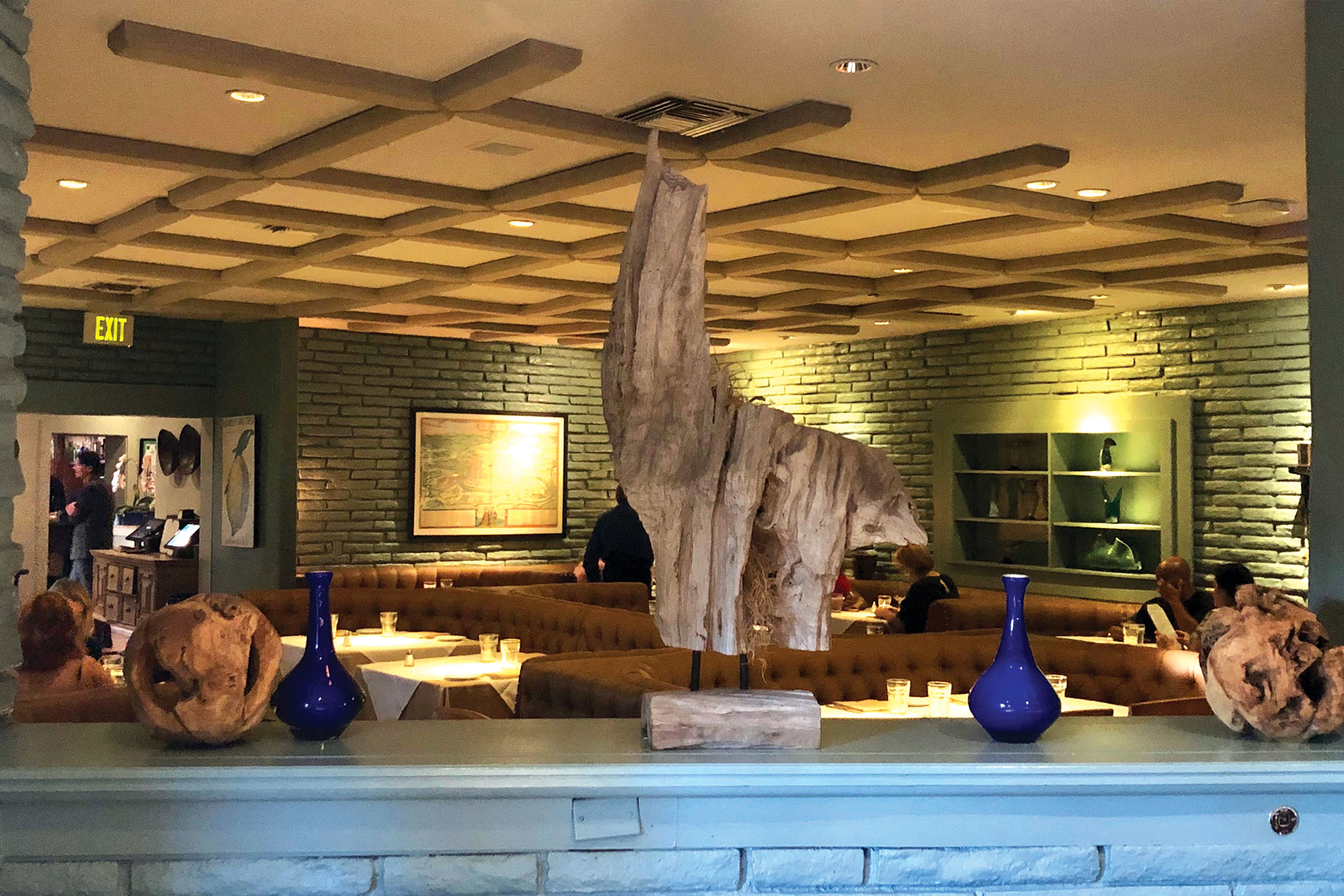 Cozy private dining setup with wooden sculptures at Ca' Del Sole restaurant.