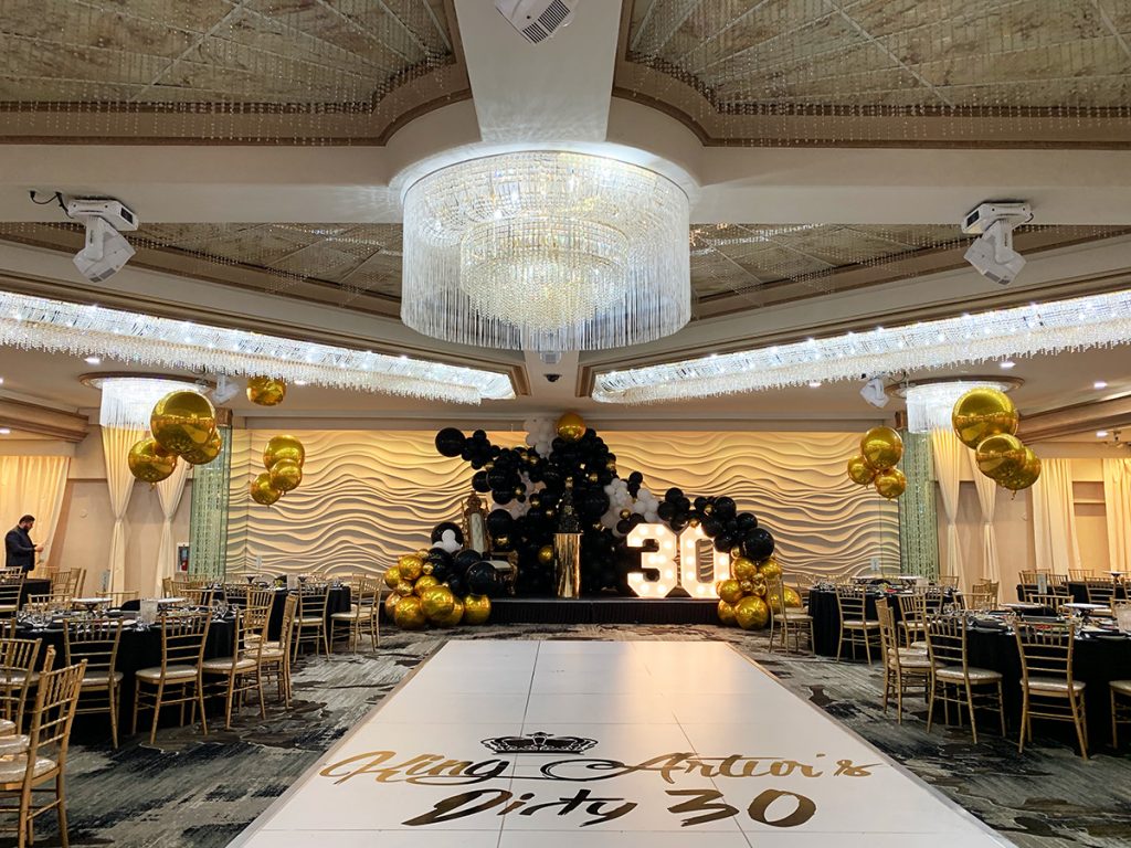 Grand Ballroom at Mirage Venue with gold and black decor for a milestone celebration.