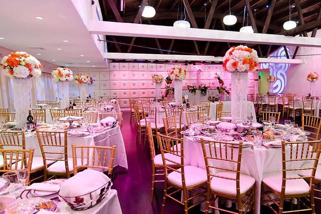 Elegant reception hall with white tables and gold chairs, perfect for weddings and upscale events.
