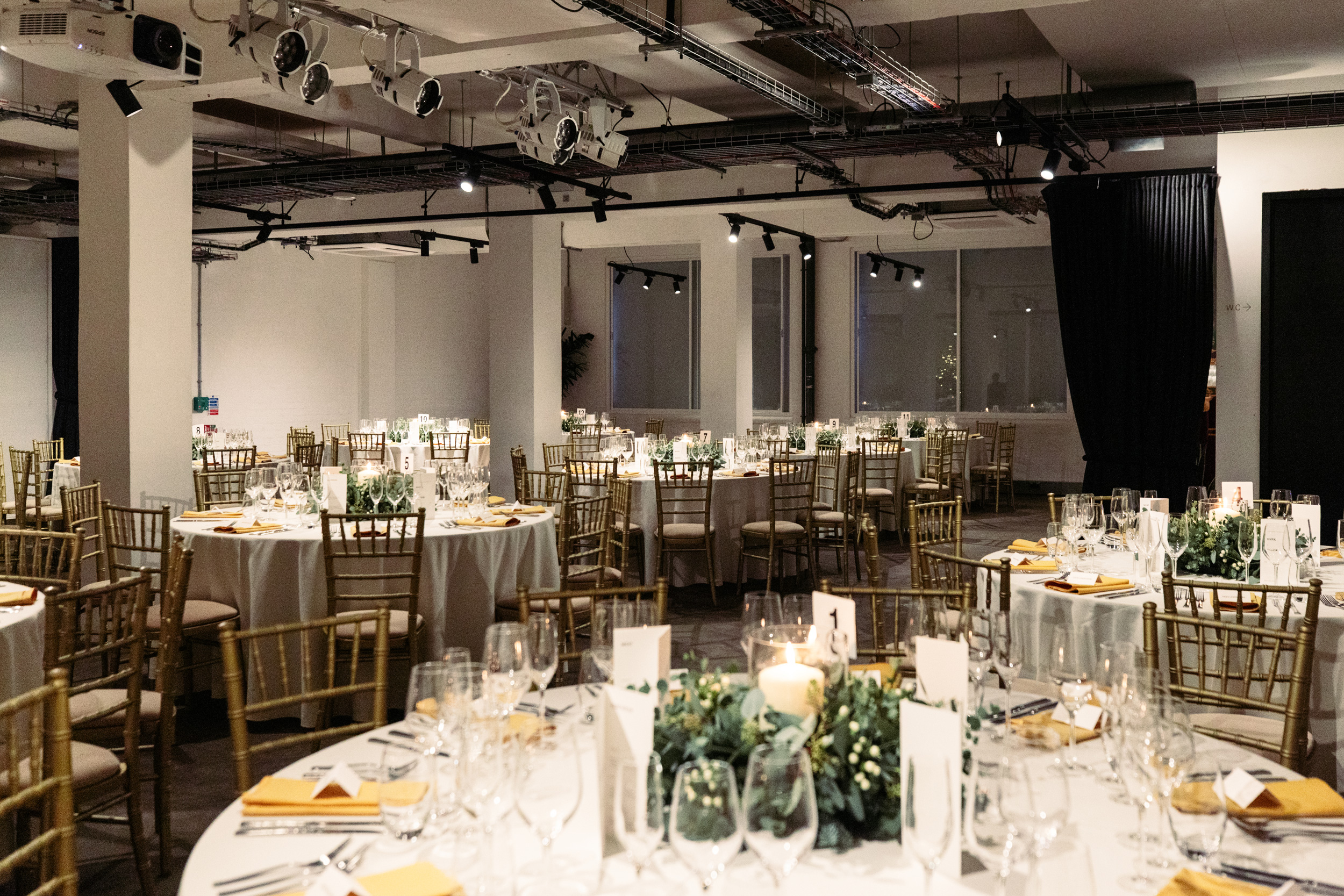 Elegant event space with round tables, perfect for weddings and corporate gatherings.