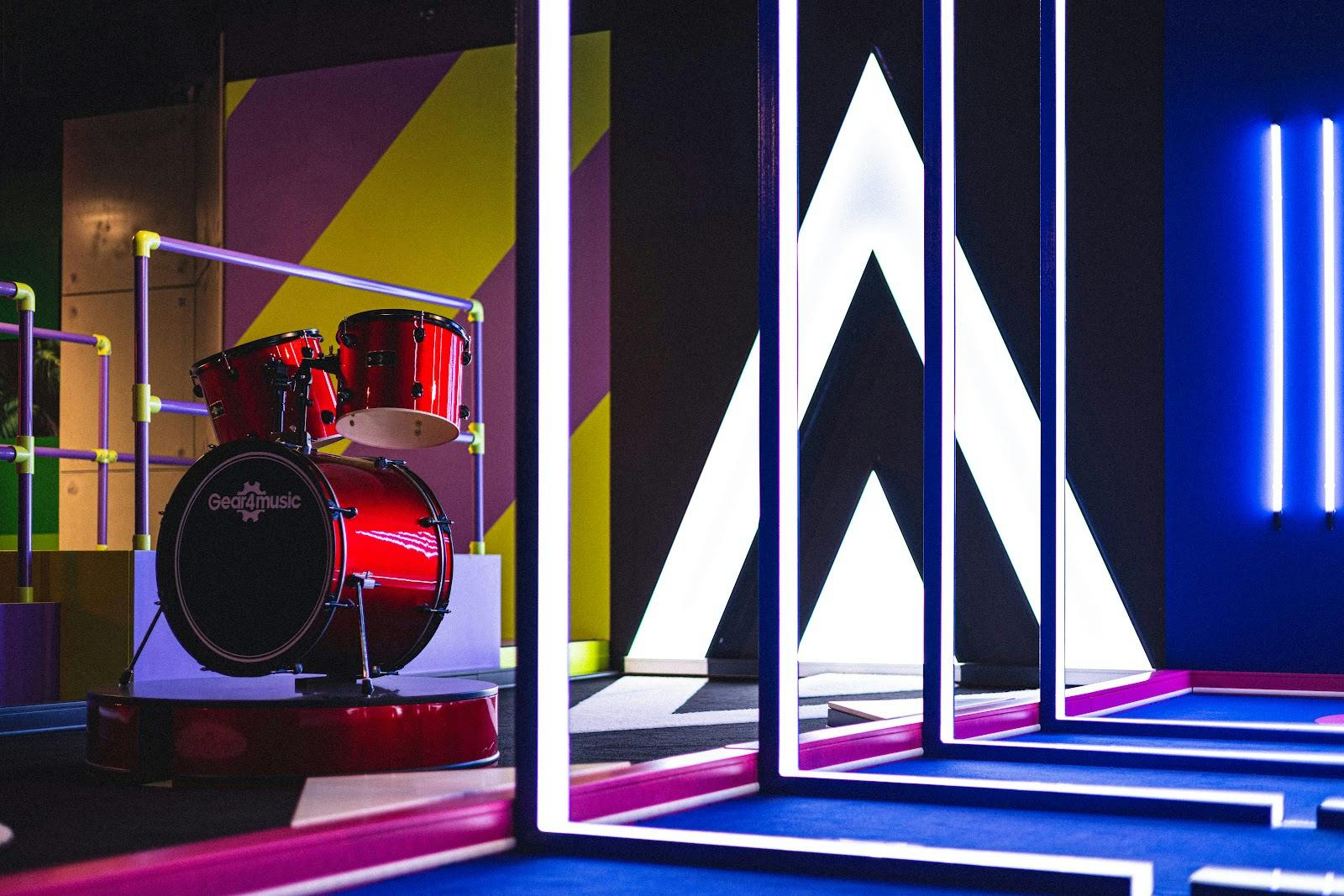 Vibrant B-Side event space with red drum set, ideal for creative gatherings and live music.