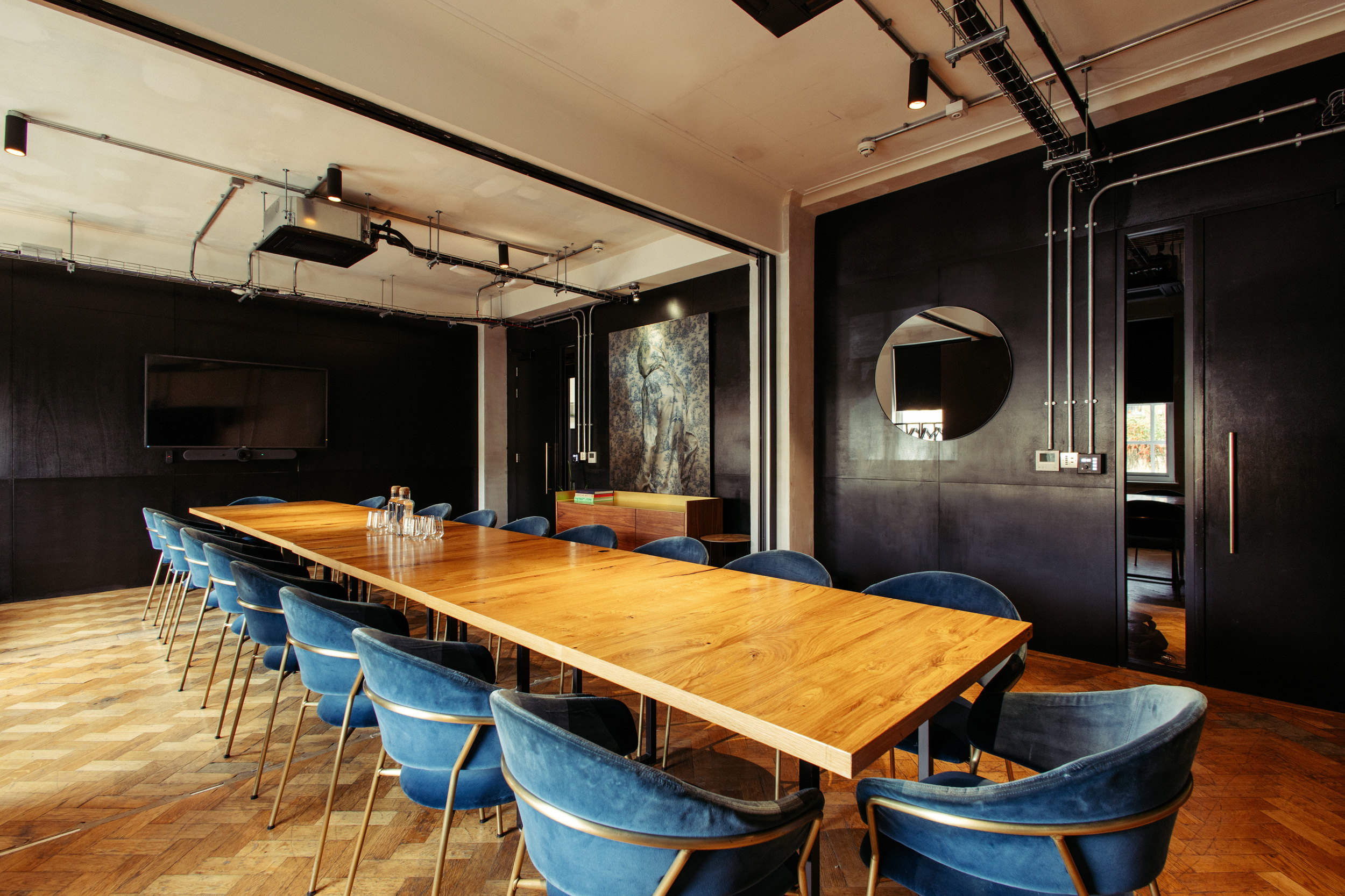 Modern meeting room with wooden table and blue chairs, perfect for corporate workshops.
