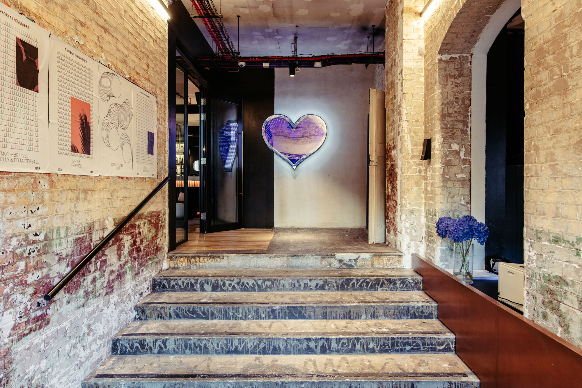 Stylish venue entrance with neon heart, ideal for creative events and networking.