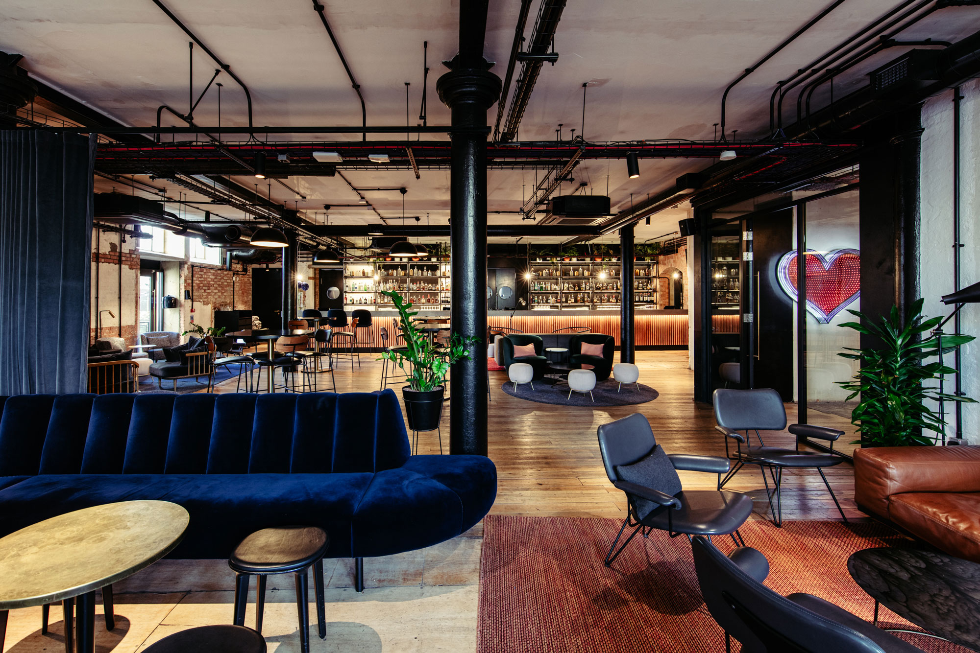 Modern event space with inviting bar and greenery, perfect for meetings and gatherings.