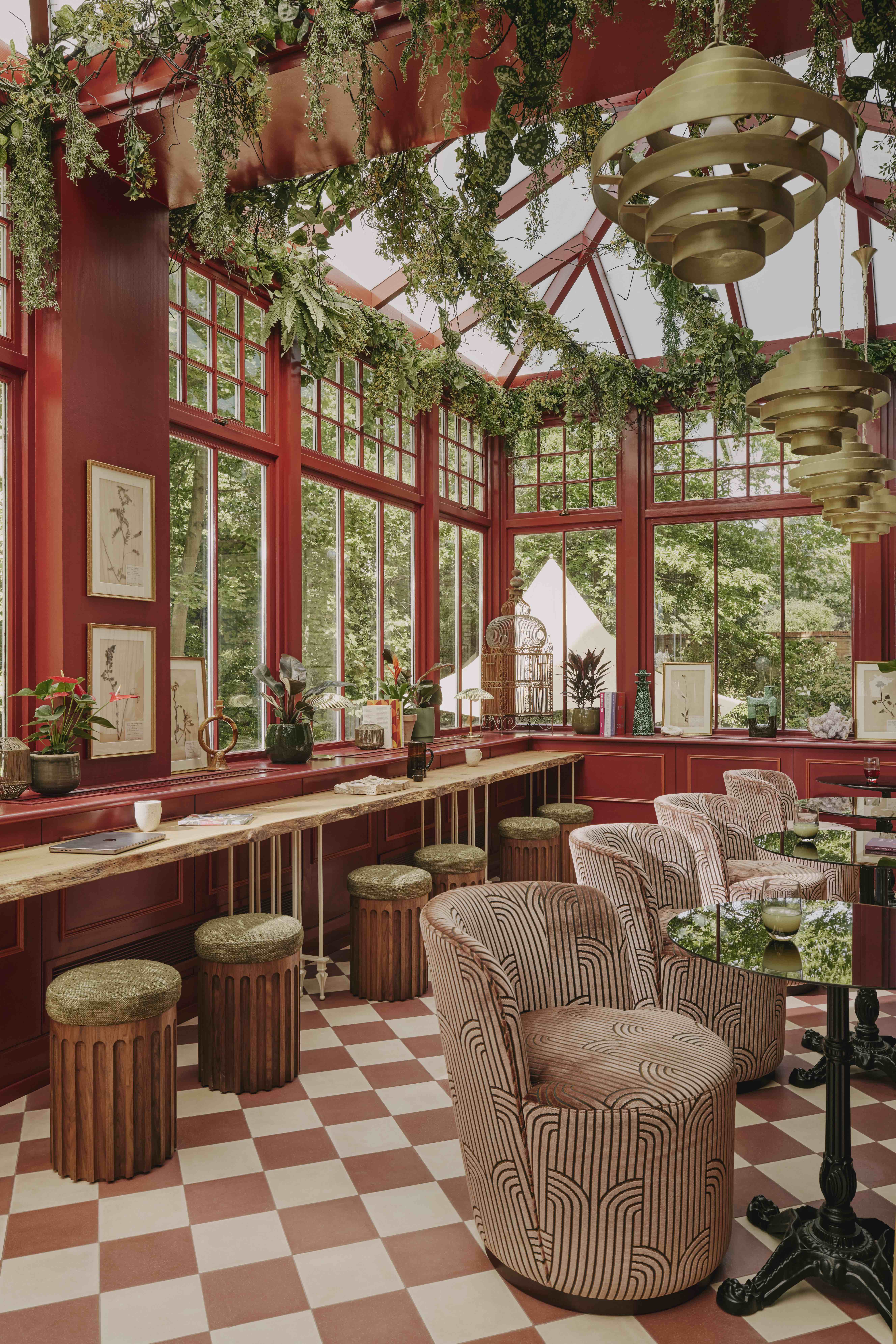 Elegant event space in EVE Kensington with large windows and rich red walls.