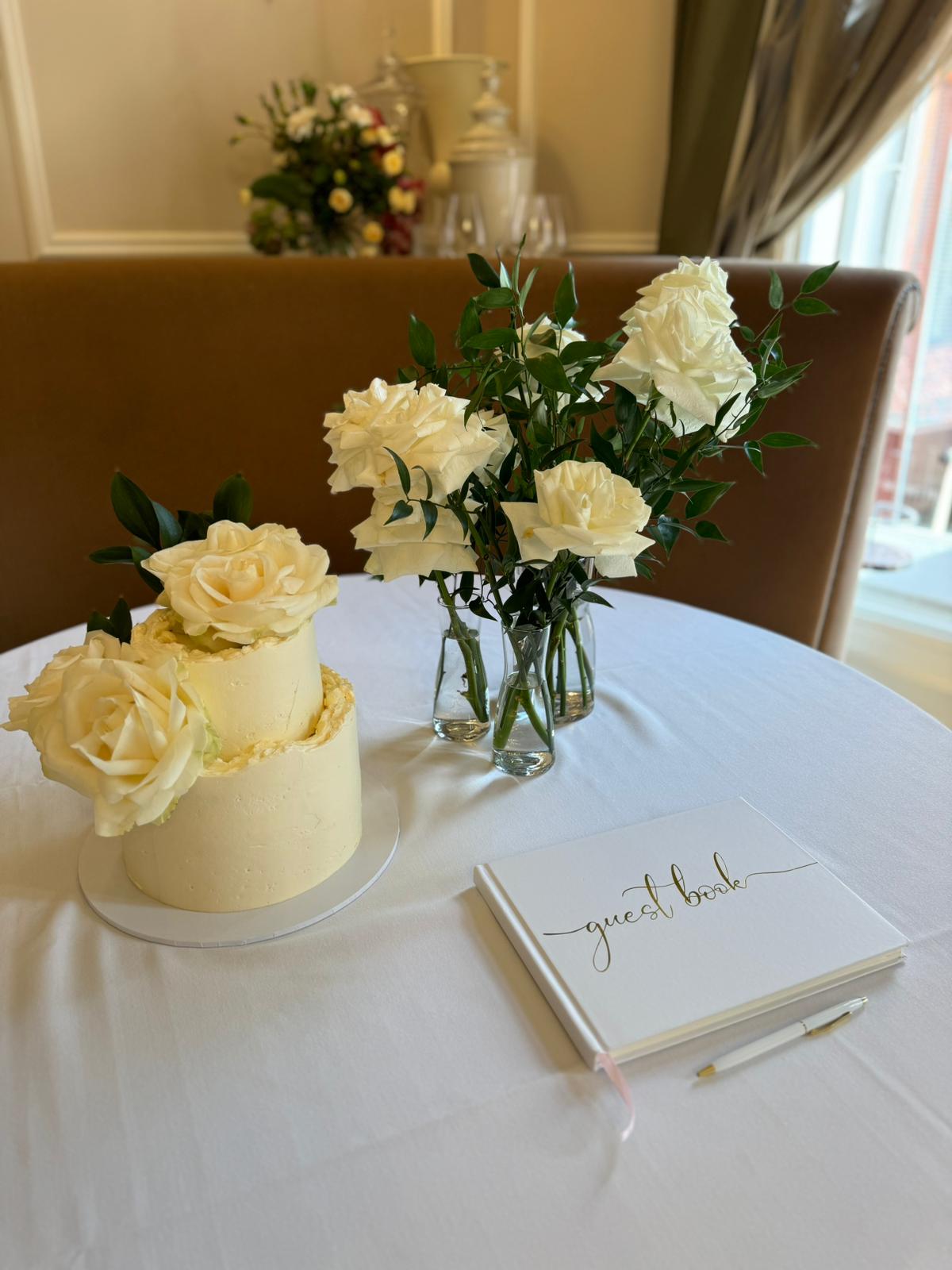 Elegant wedding setup in The Churchill Room with a white rose cake and decor.