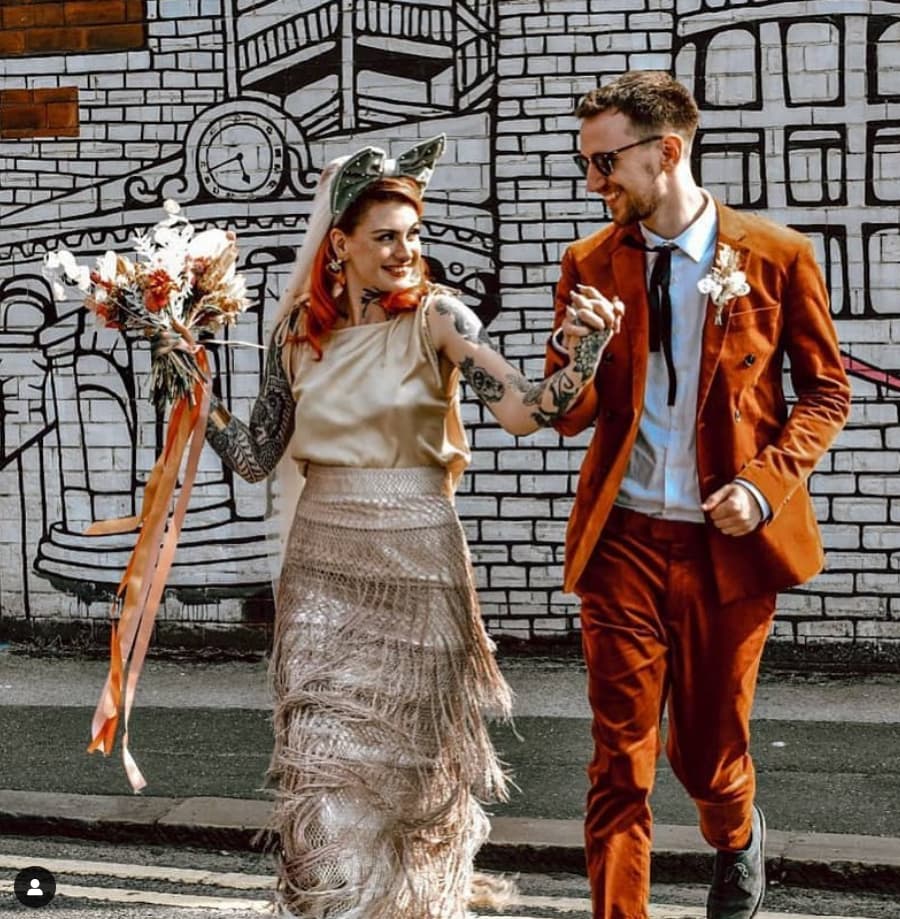 Stylish couple celebrating modern wedding against vibrant mural backdrop in The Furnace.