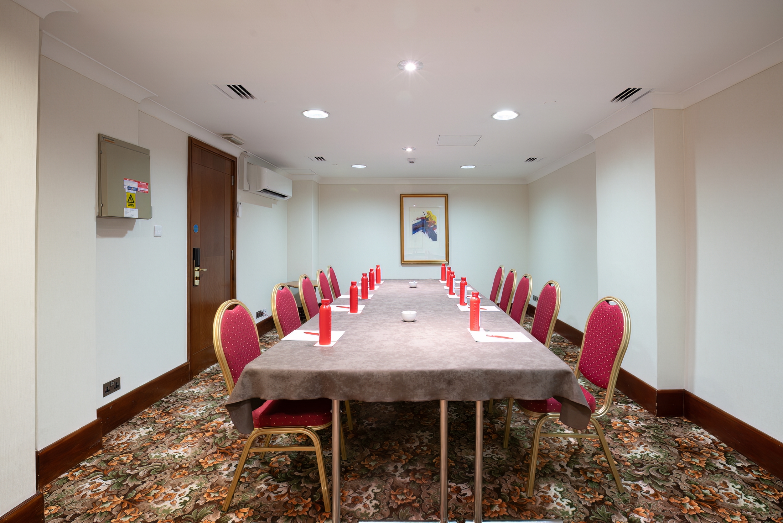 Princess Boardroom in London: elegant meeting room with red accents for corporate events.