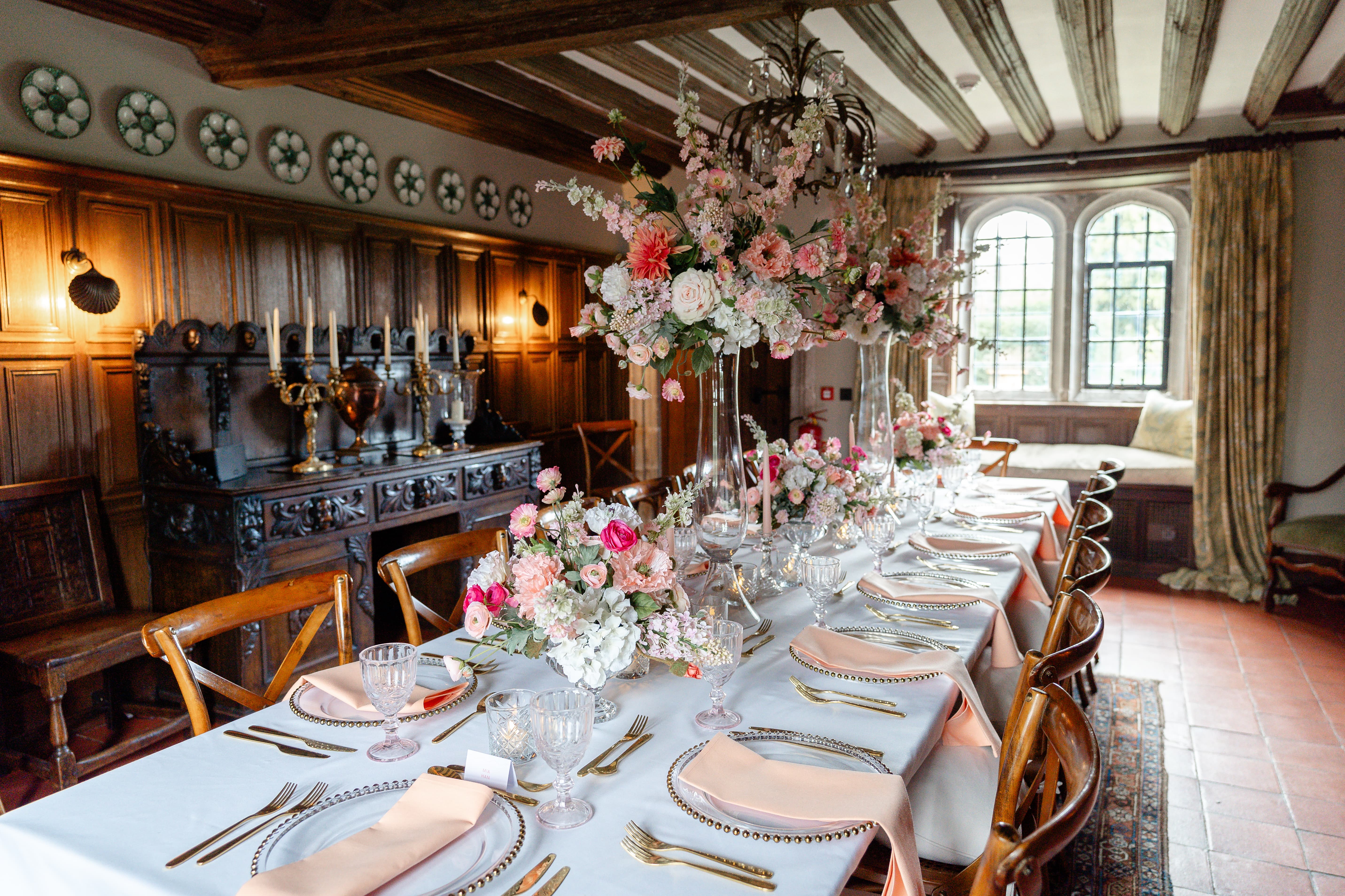 Intimate luxury dinner at Leeds Castle, Battel Hall with floral centerpieces for wedding events.