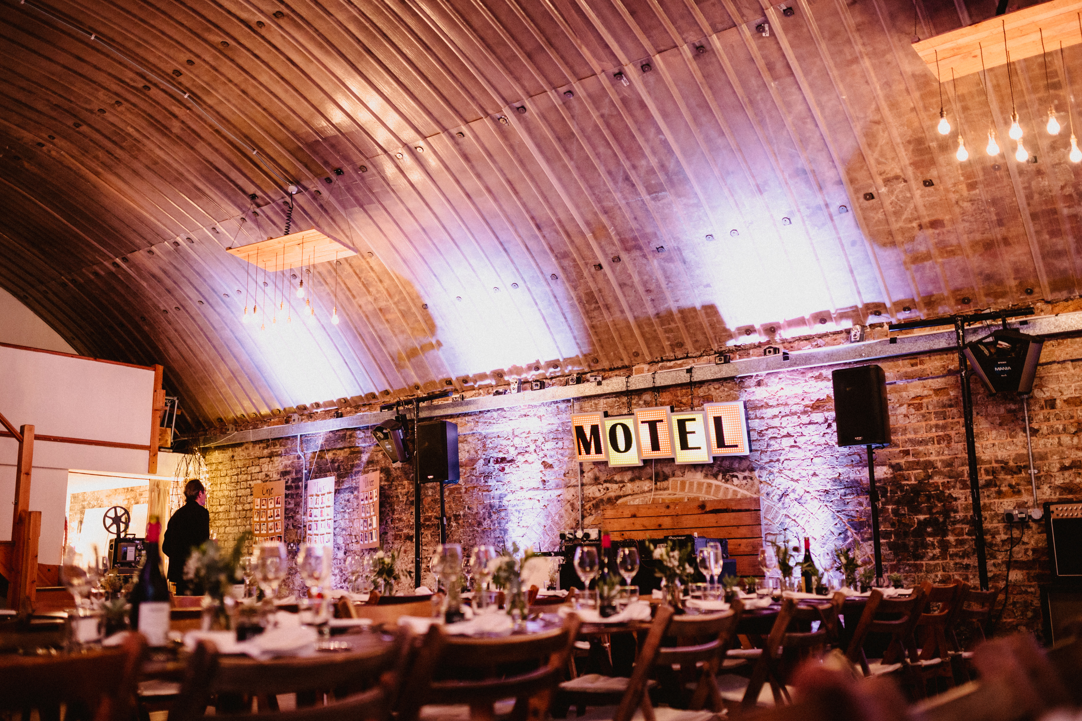 Rustic event space in MOTEL with wooden tables and elegant centerpieces for celebrations.