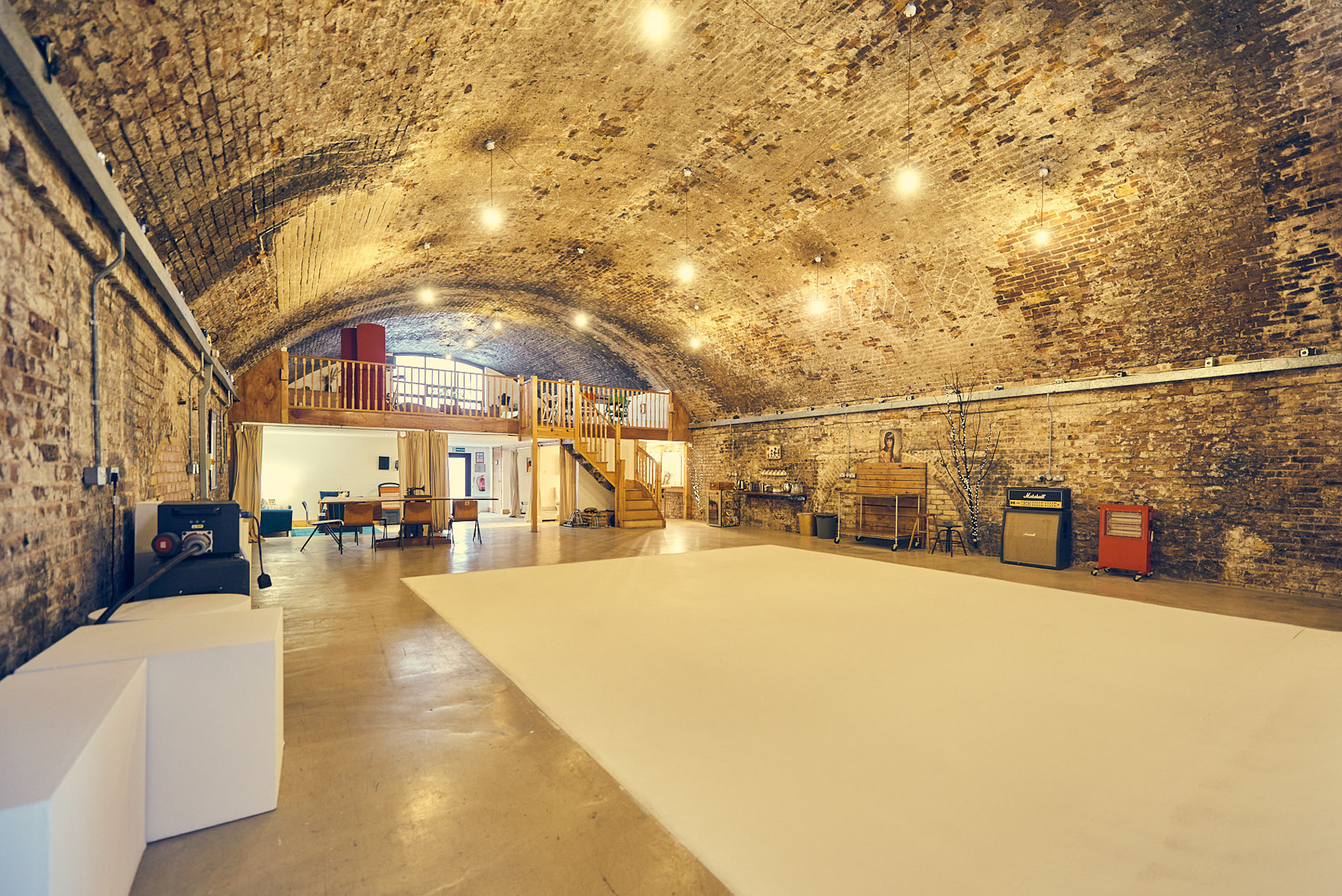 Spacious event venue with arched brick ceiling, ideal for workshops and gatherings.
