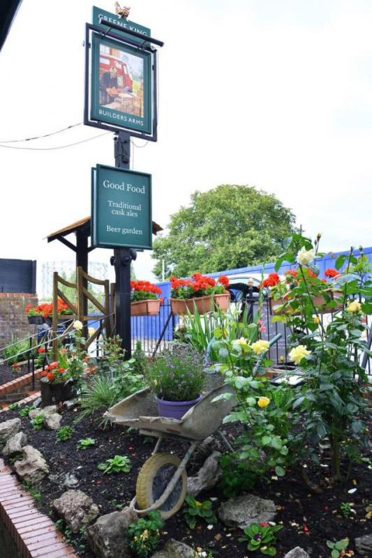 Beer garden at Builders Arms with vibrant flowers, ideal for alfresco dining events.