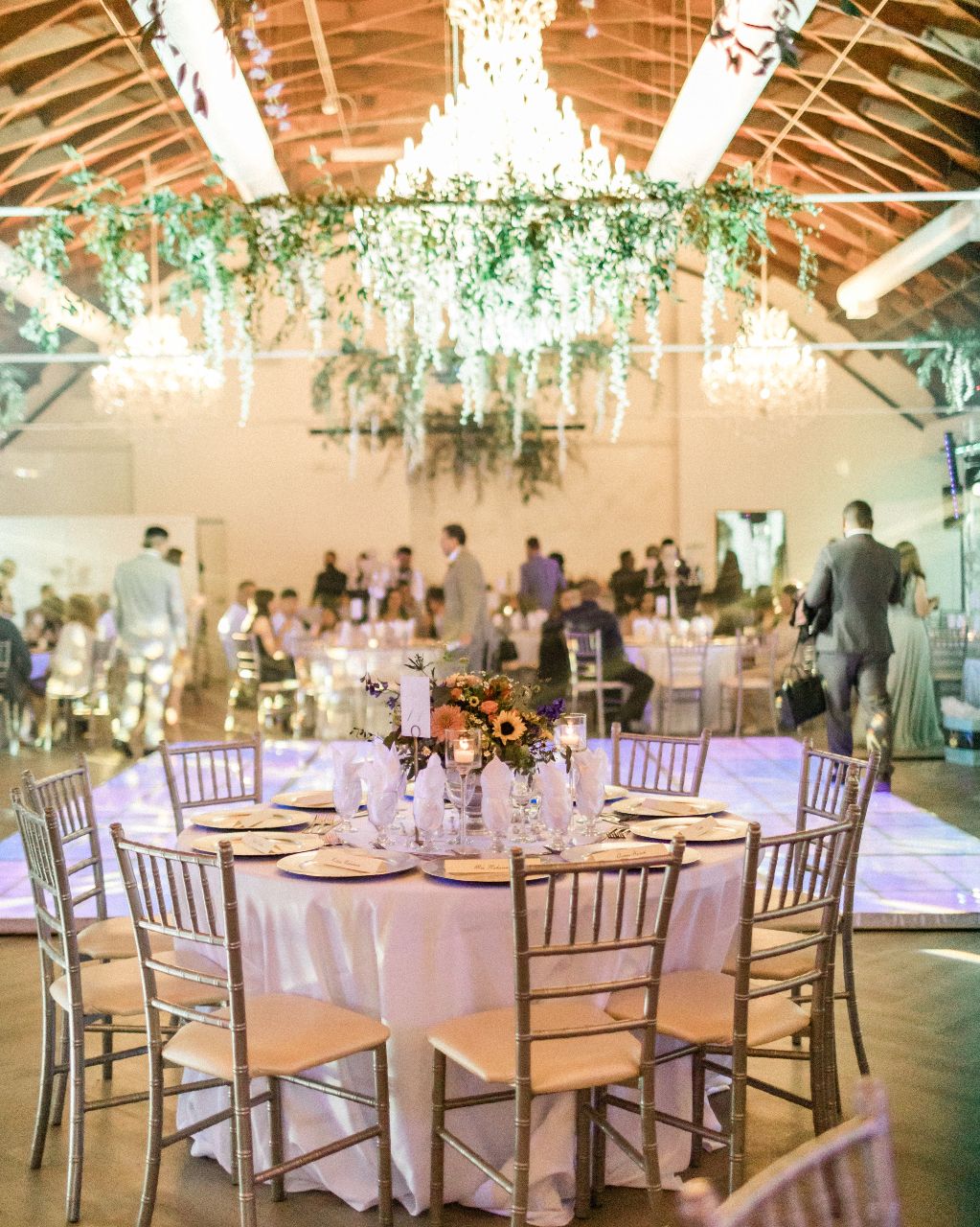 Elegant event space in VASA San Diego with chandeliers and lush greenery for gatherings.