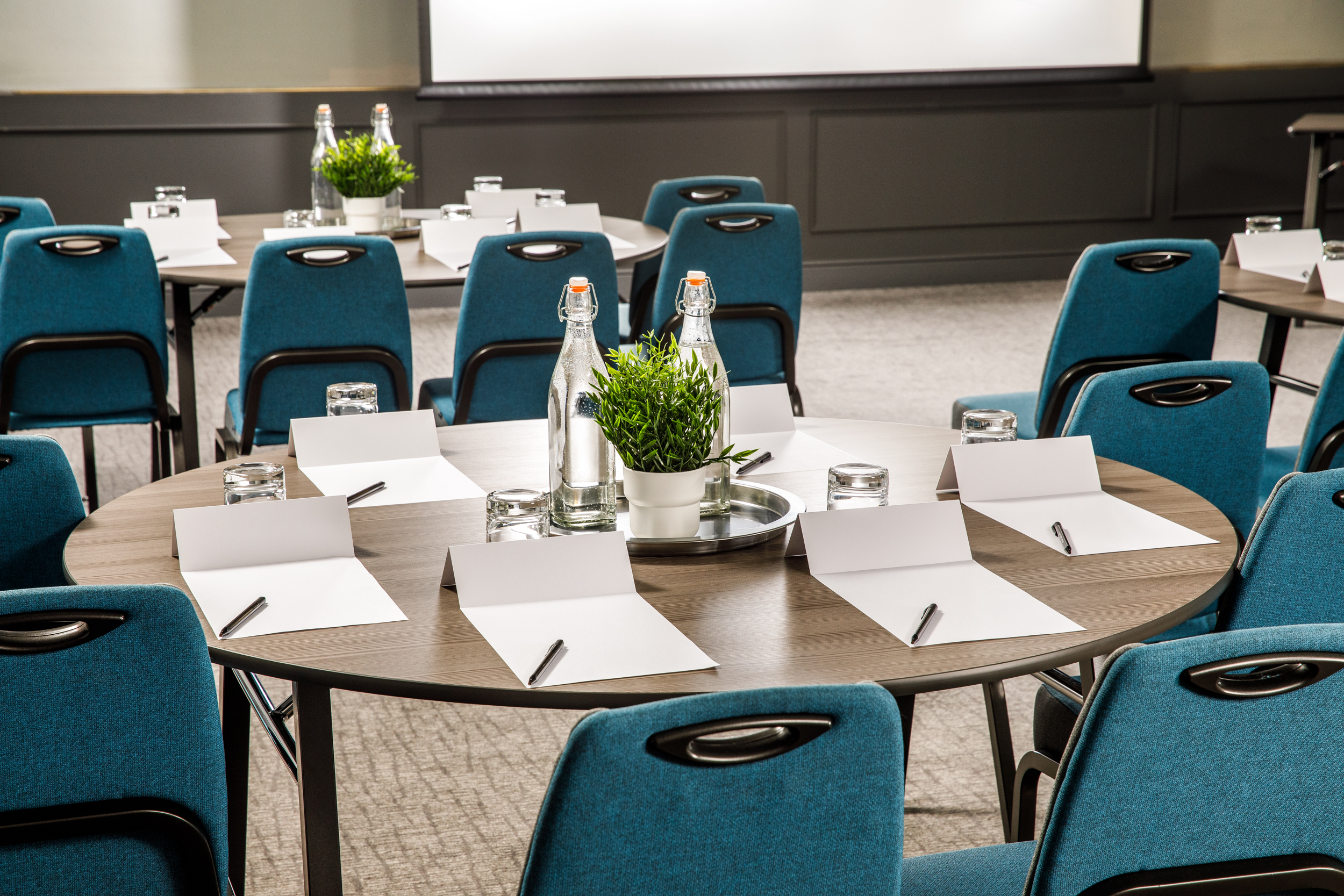 Chase Suite meeting space with round tables, notepads, ideal for workshops and brainstorming.