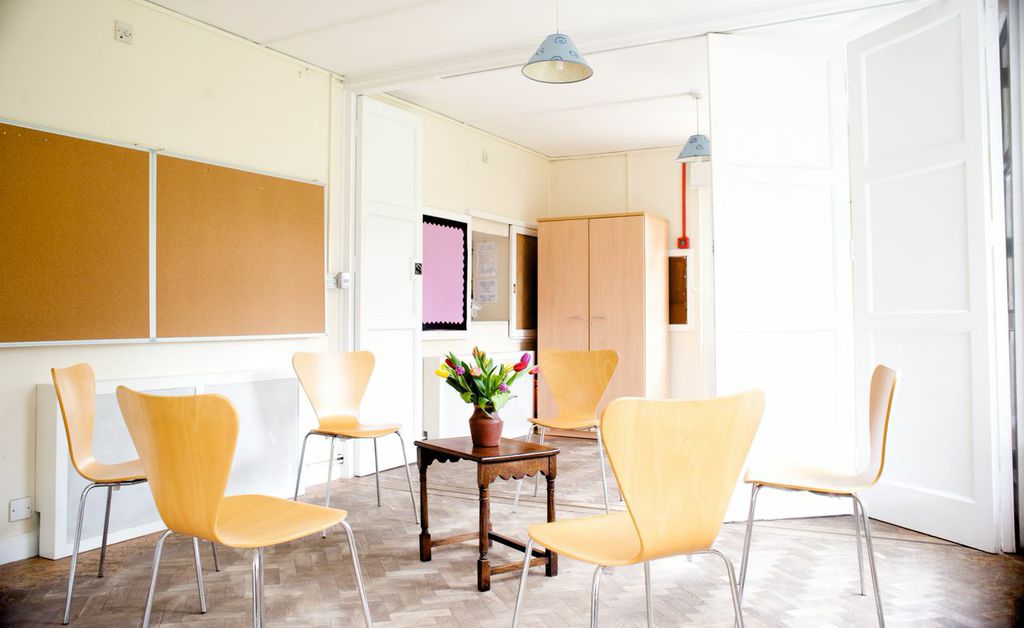 Bright minimalist meeting room with wooden chairs for workshops in Brentford & Isleworth.
