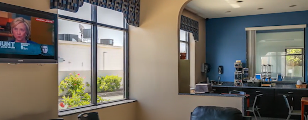 Meeting space at Regency Inn & Suites, Moreno Valley with natural light and TV for presentations.