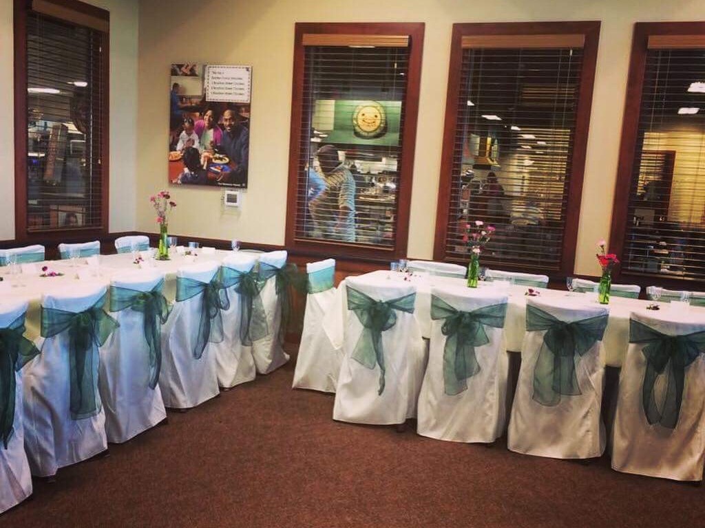 Private dining room with long table, aqua chair sashes for corporate events or celebrations.