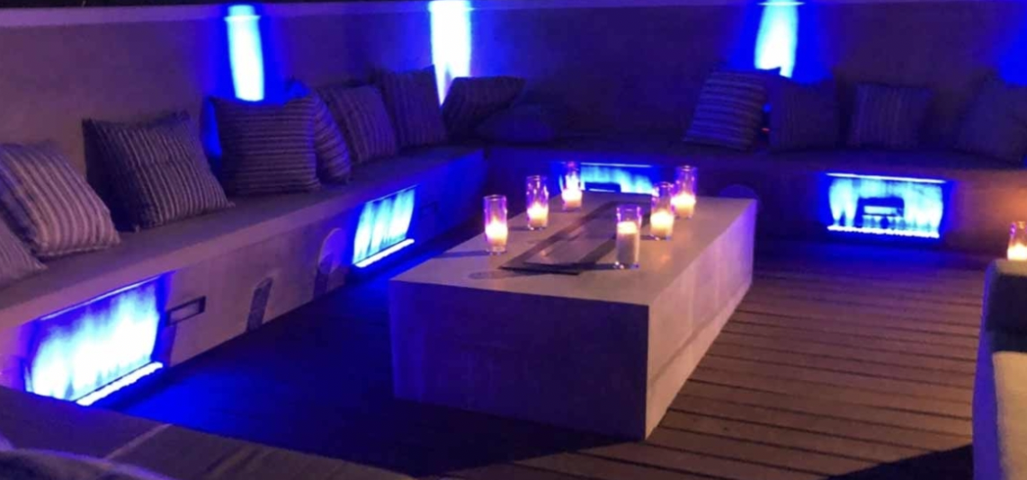 Bridal party in stylish outdoor lounge with blue lighting for networking events.