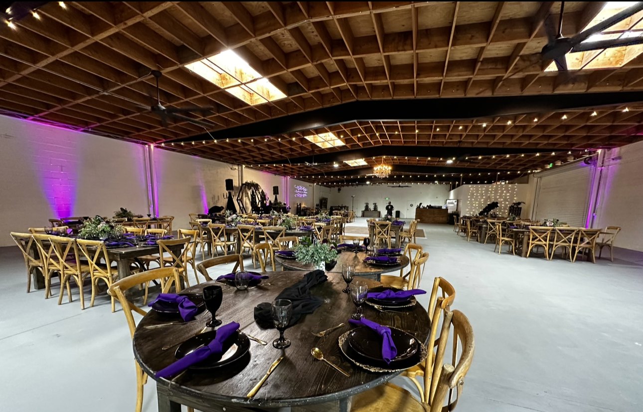 Cupcake stands in elegant event space with black and purple decor for weddings or corporate events.