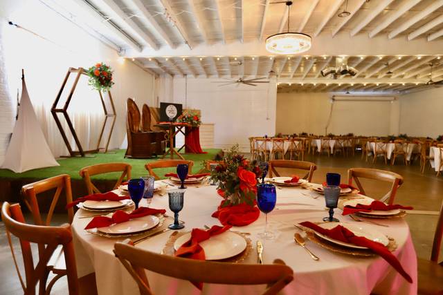 Dessert table with floral centerpiece in rustic event space for celebrations.