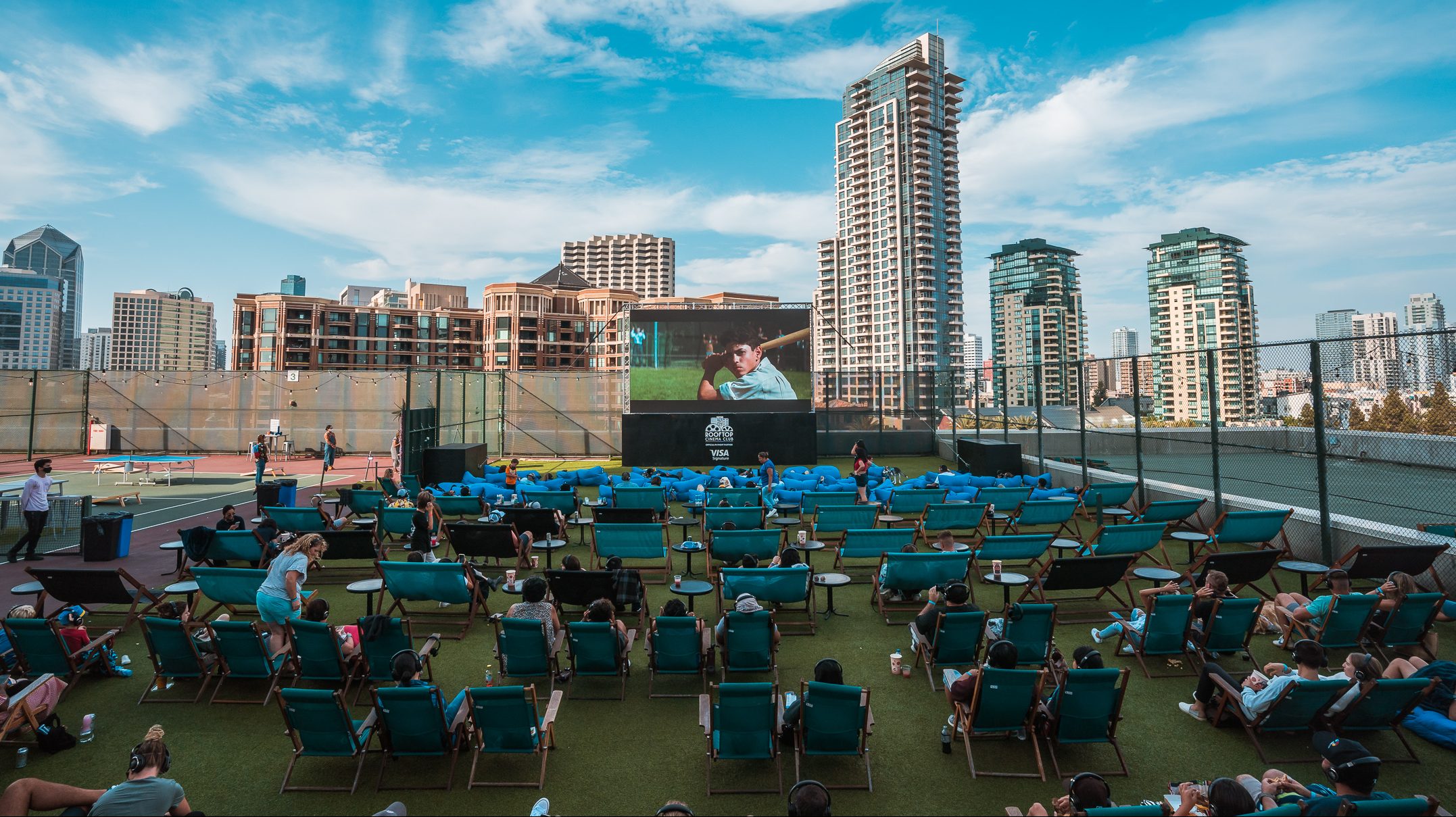 Rooftop cinema with large screen, lounge chairs, ideal for movie nights and events.