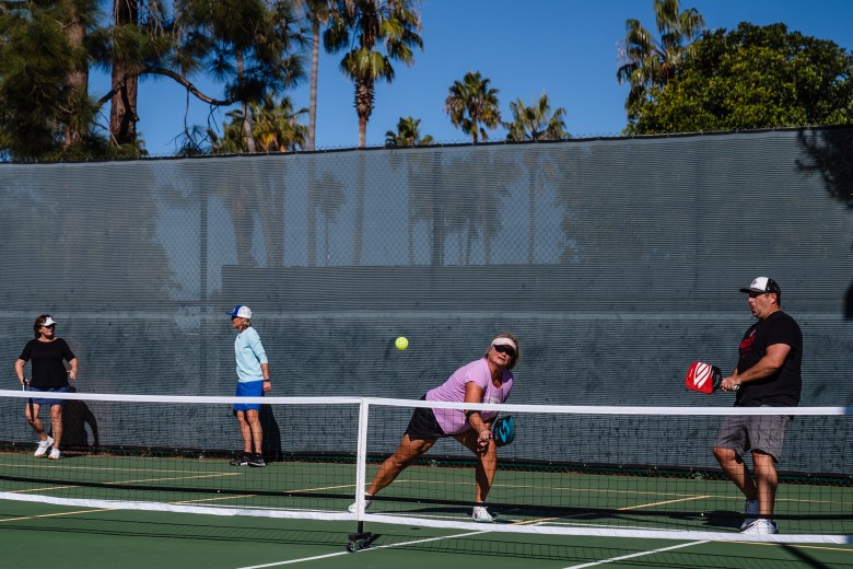 Outdoor tennis event at Point Loma Tennis Club with palm trees, ideal for team-building.