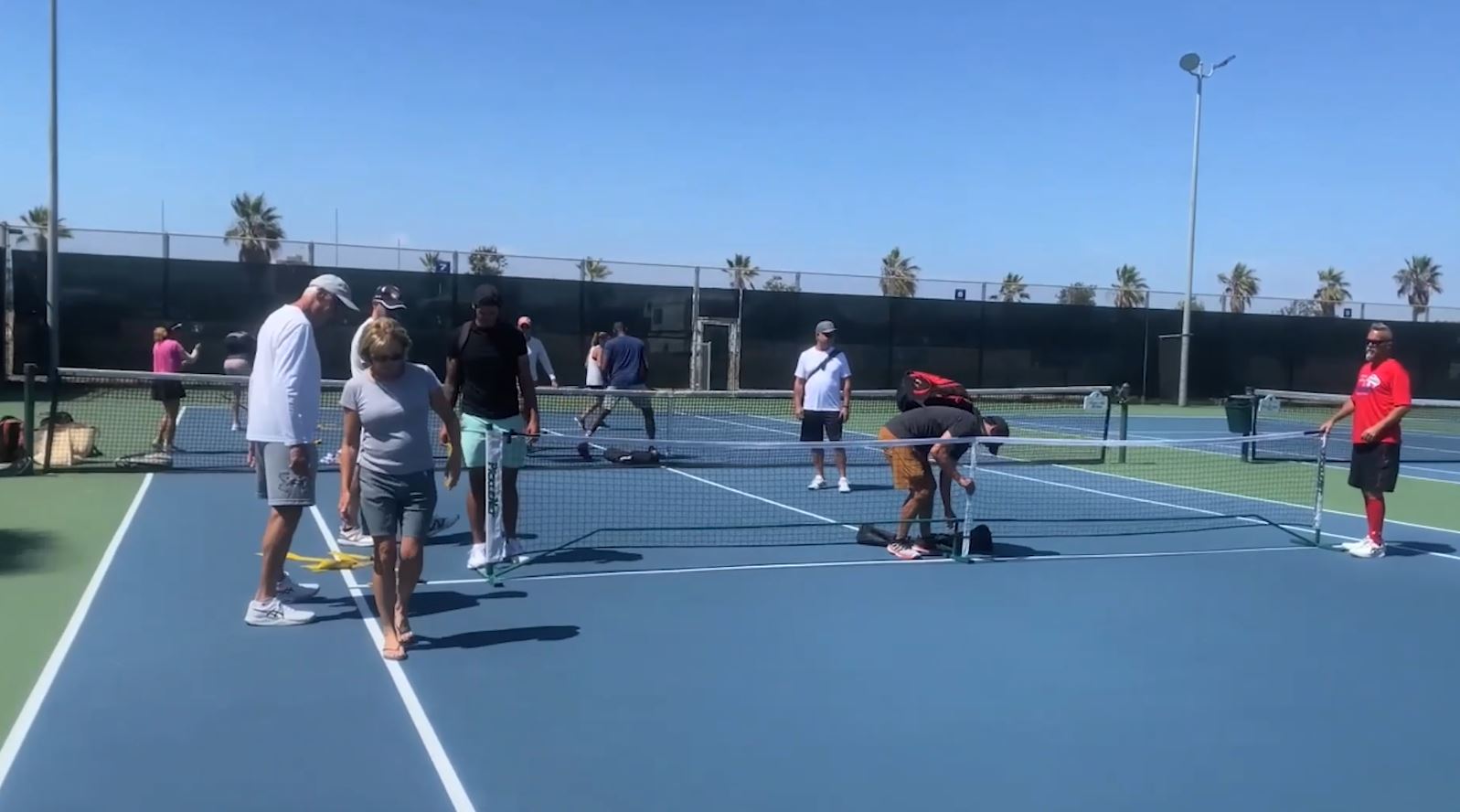 Outdoor tennis event at Point Loma Tennis Club with nets and palm trees, ideal for networking.