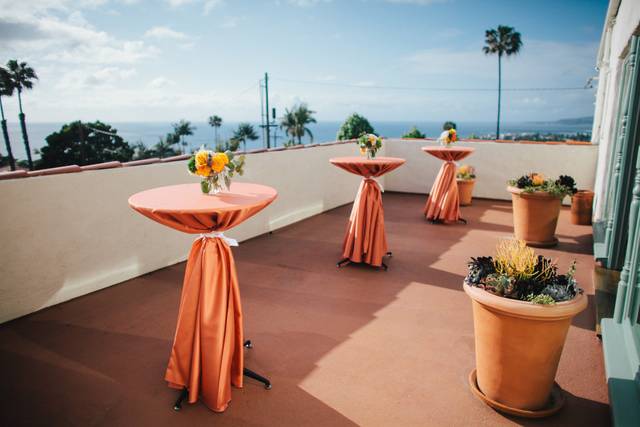 Balcony at The Thursday Club with elegant orange linens, ideal for networking events.