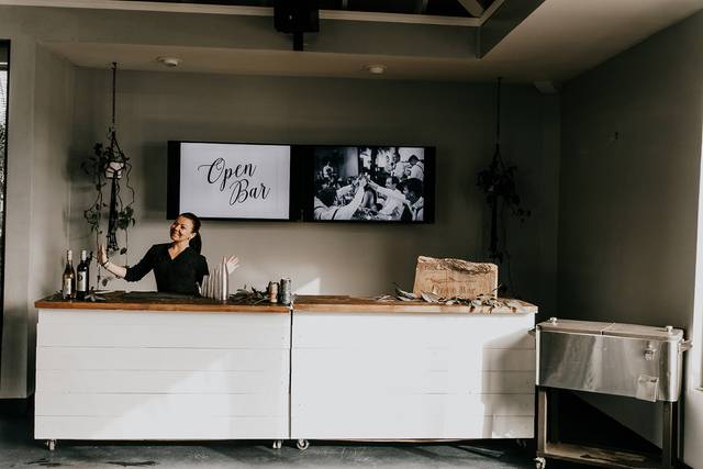 Stylish open bar with friendly bartender in modern indoor event space at The Point.