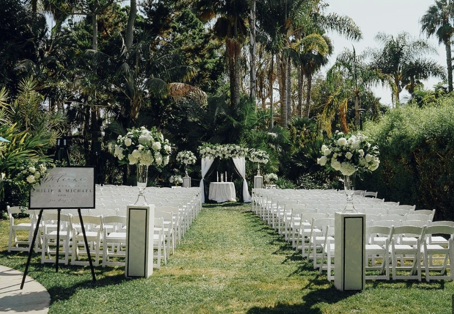 Outdoor wedding setup at Island Point Lawn with white chairs and floral arrangements.