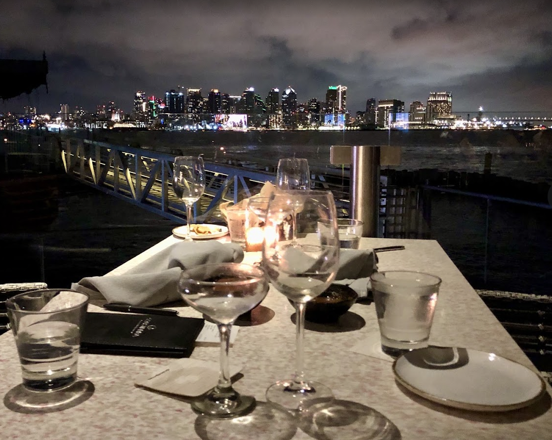 Elegant dining table with glassware, city skyline view for upscale events in Coasterra.
