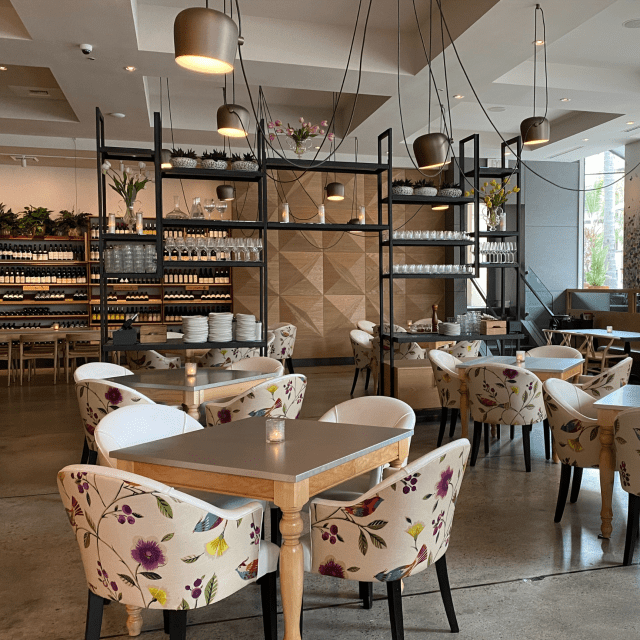 Modern dining space with floral chairs at The Kitchen @MCASD, perfect for events.