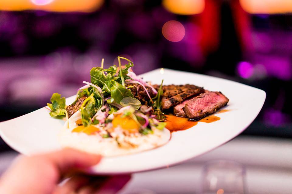 Grilled steak with salad at STK Steakhouse, perfect for corporate events and upscale dining.