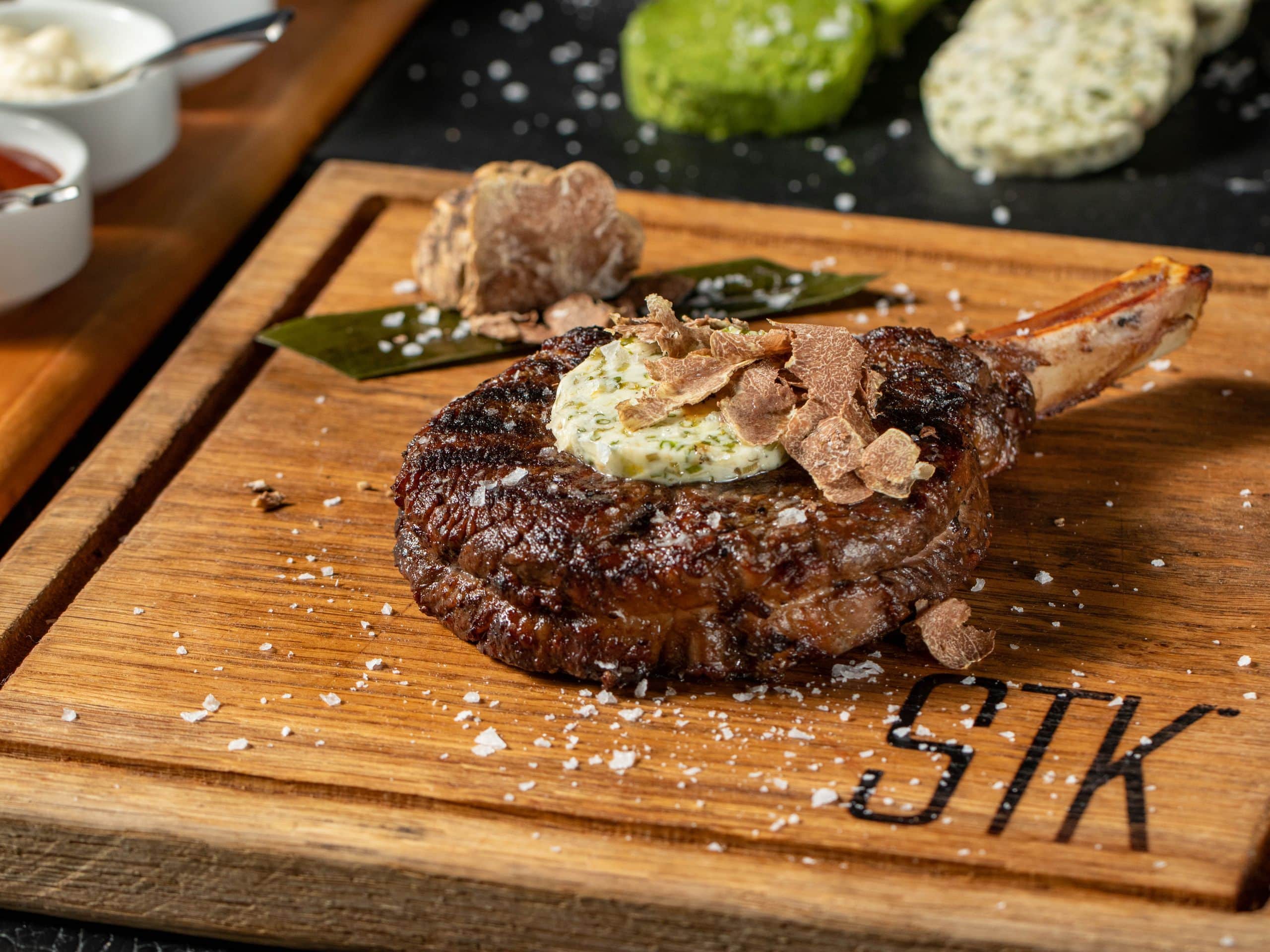 Steak on wooden board at STK Steakhouse, perfect for upscale corporate dinners and events.