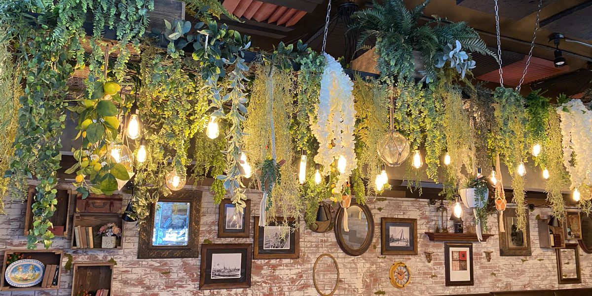 Rusticucina patio with lush greenery, warm lighting for intimate gatherings and workshops.