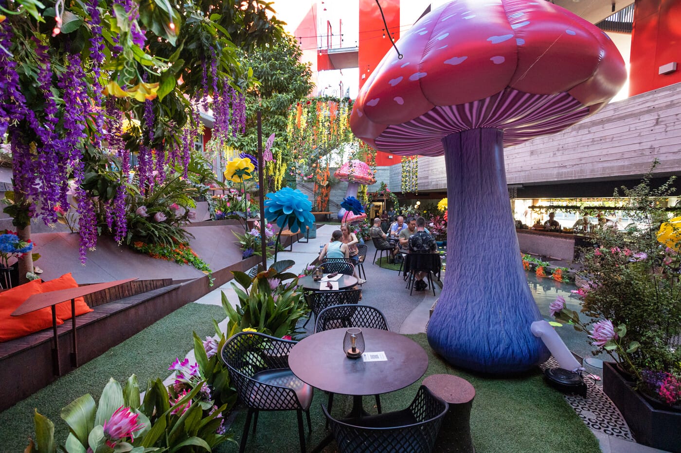 Vibrant outdoor lounge with oversized mushrooms for creative events and networking.