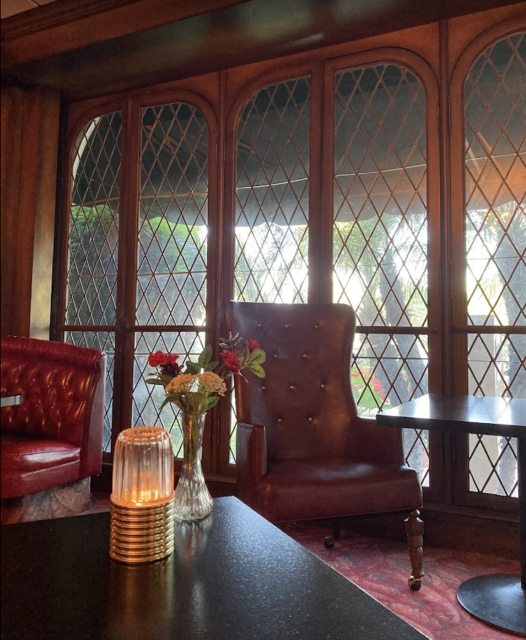 Cozy meeting space at IMPY Bar & Grill with plush burgundy seating for gatherings.