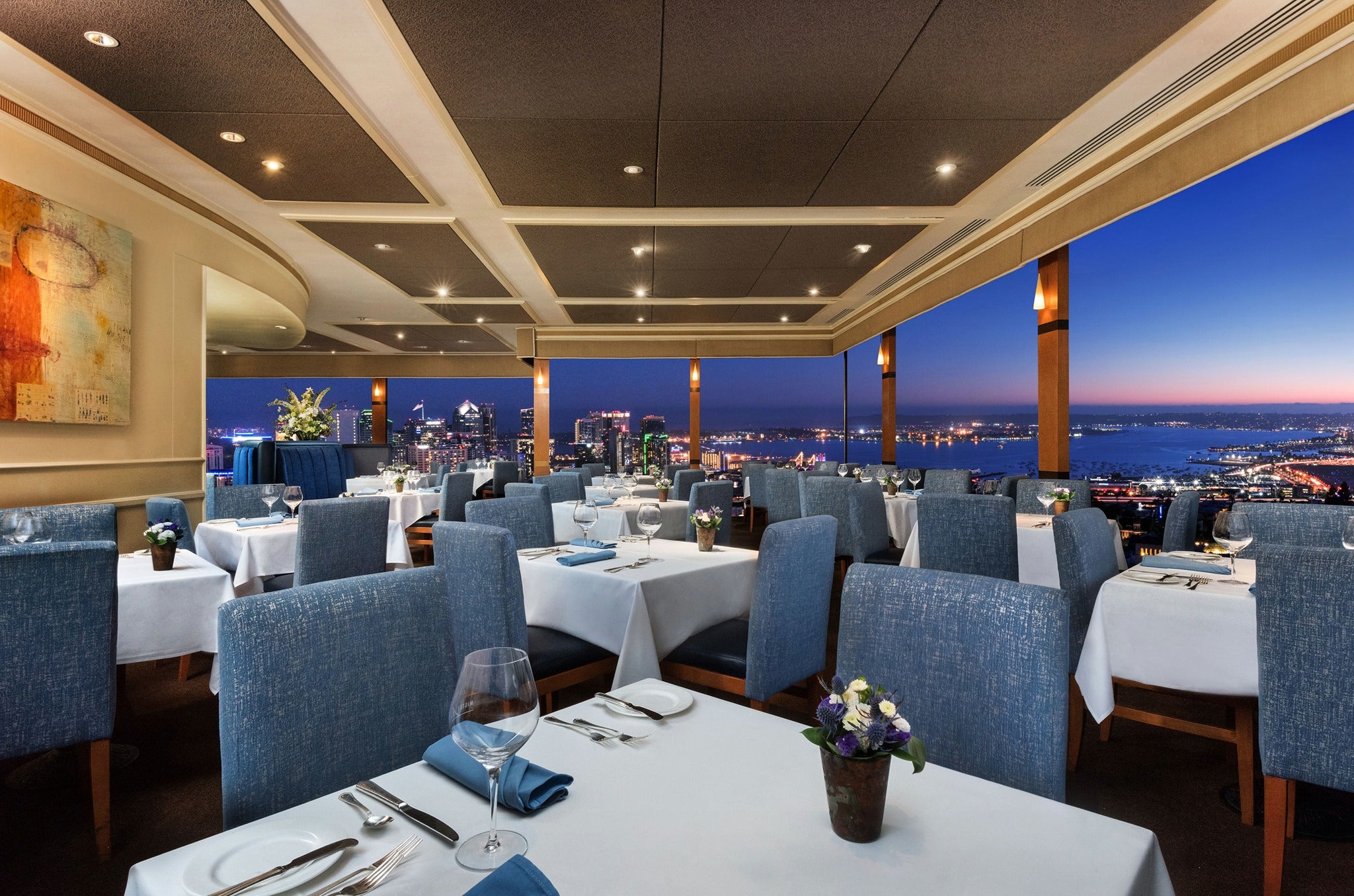 Outdoor deck at Mister A's Restaurant with elegant tables and city skyline, perfect for events.