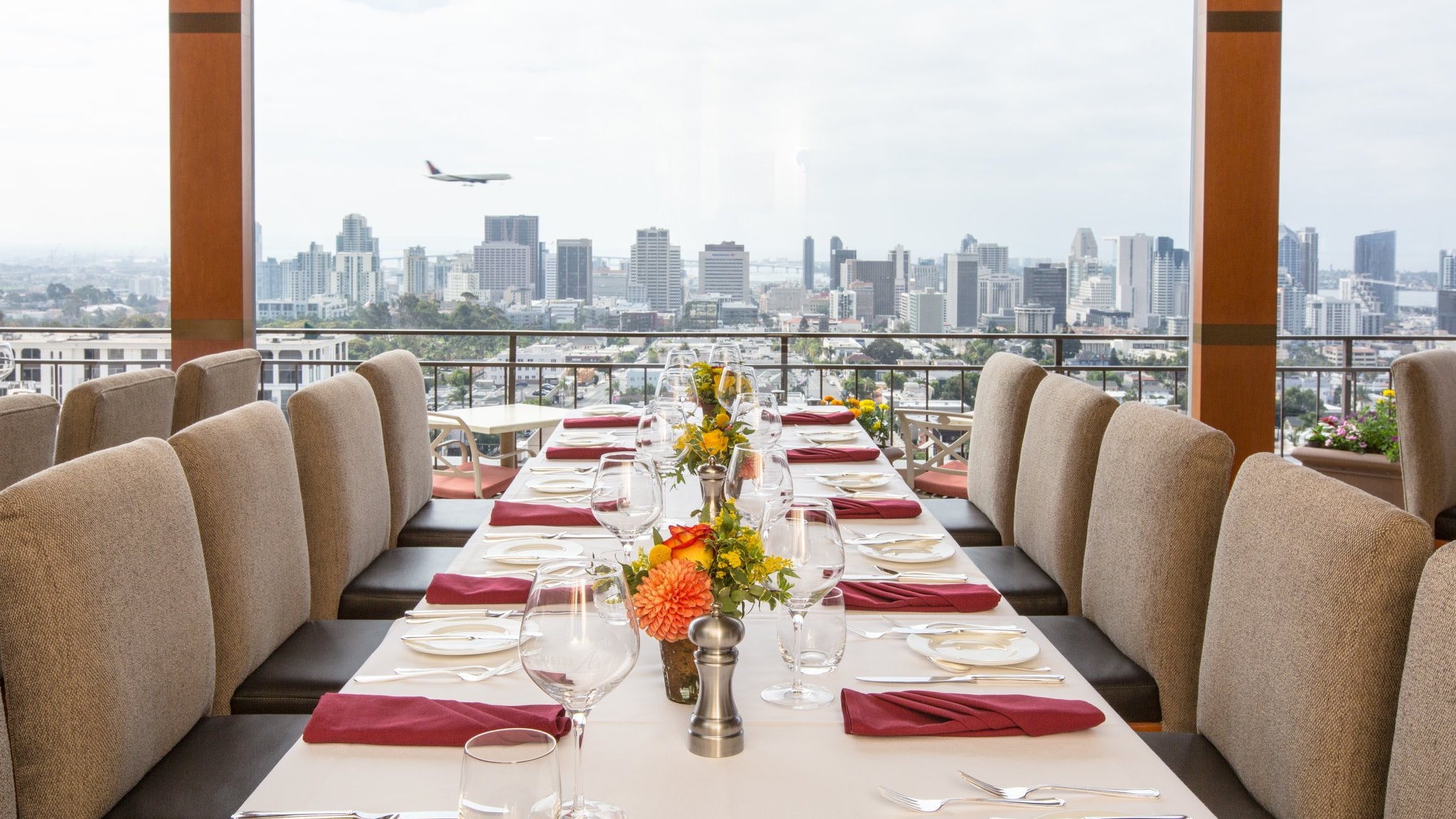 Formal dining area at Mister A's with city skyline, perfect for upscale events and gatherings.