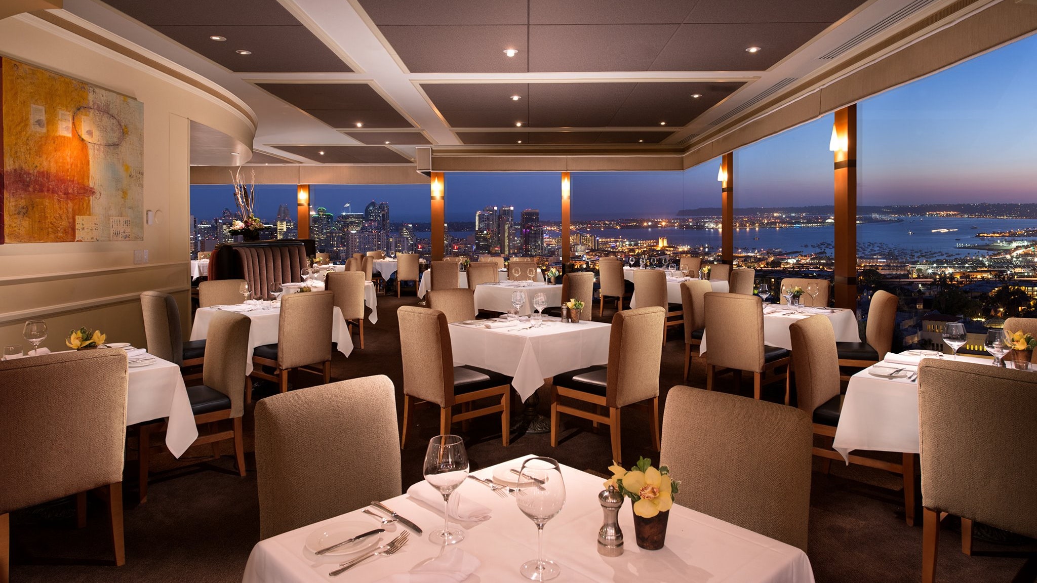Formal dining area at Mister A's Restaurant with elegant settings and city views.