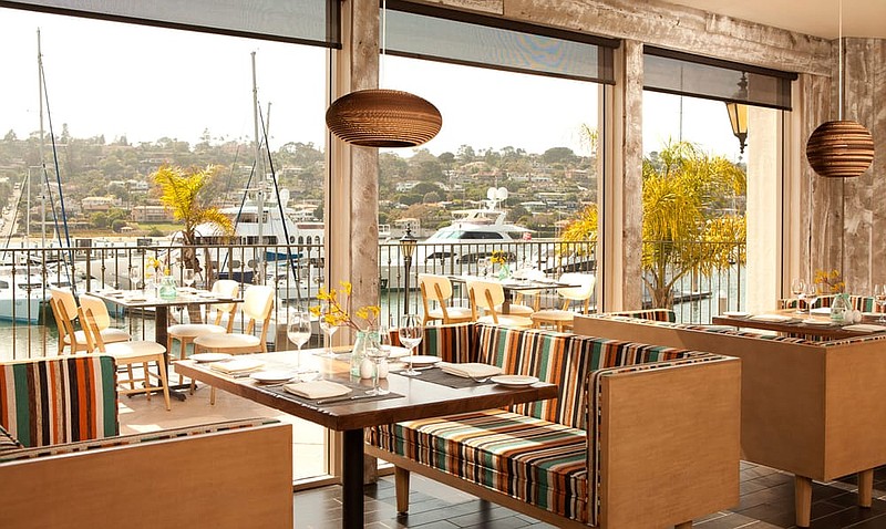 Stylish waterfront restaurant bar with vibrant seating, perfect for events and gatherings.